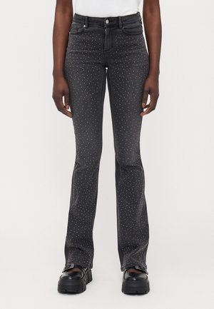 Sorte denim flare jeans med middels høy midje, prydet med små hvite nagler over hele. Solid stoff med liten strekk.
