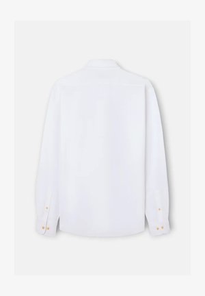 Camisa blanca de manga larga con botones vista desde atrás, con cuello clásico y puños abotonados sobre un fondo claro.