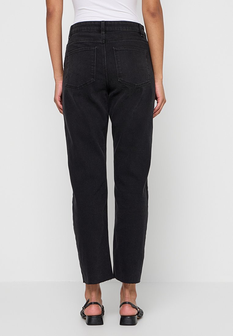 Schwarze hochgeschnittene Jeans mit geradem Bein, fünf Taschen und klassischer Denim-Textur, die minimalistische Nähte und klare Linien zeigt.