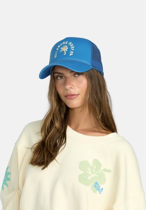 Gorra snapback azul con visera curvada, con bordado blanco de palmeras y el texto "BILLABONG SURF CO.". Parte trasera de malla para mayor transpirabilidad.