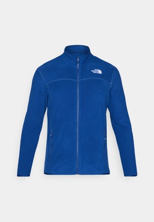 Blue fleece jacket with zip front, high collar, and two side pockets. Features the North Face logo in white on the upper left side.