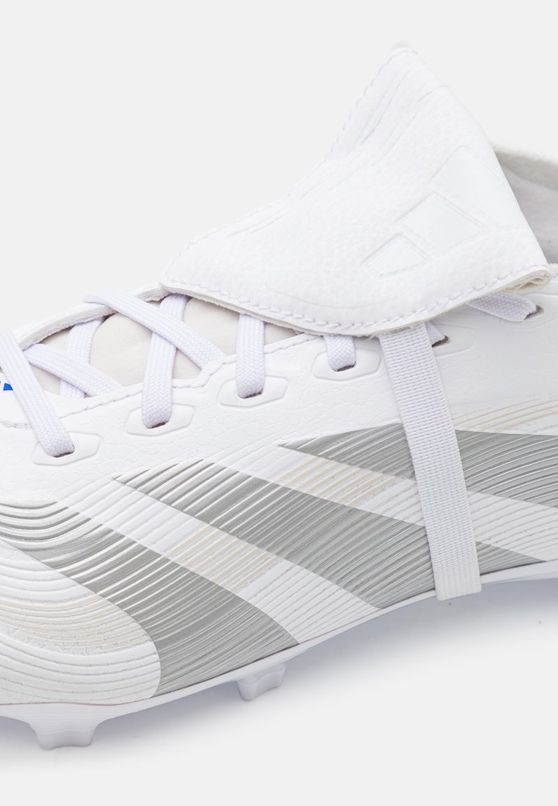 Scarpa da calcio bianca con accenti argentati, parte superiore testurizzata, chiusura con lacci e pattina pieghevole. Presenta un design a tre strisce prominenti.