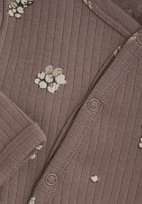 Brun ribbad kofta med blomstermönster i krämfärg. Har matchande knappar och mjuk textur, lämplig för lager-på-lager.