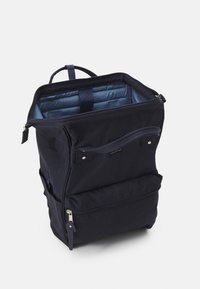 Tummansininen kangaskantoreppu, jossa on suorakulmainen muoto, ylhäällä vetoketju, ulkopuolella etutasku ja pehmeä sininen sisävuori. Varustettu ylhäällä kahvalla.