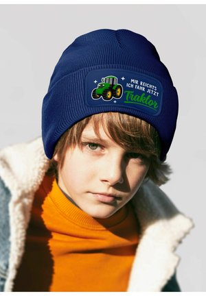 Navy blue knit beanie featuring a tractor graphic and text patch with German phrases. Soft texture, snug fit, and playful design.