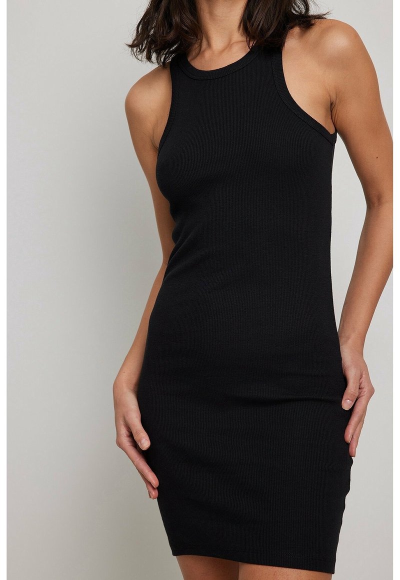 Robe noire côtelée sans manches, à coupe ajustée, avec un col rond et une texture lisse, idéale pour une tenue décontractée ou semi-formelle.