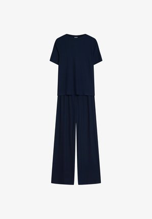 Granatowy dwuczęściowy komplet składający się z luźnej bluzki z krótkim rękawem oraz spodni o szerokich nogawkach wykonanych z prążkowanej tkaniny. Gładka tekstura na całej powierzchni.