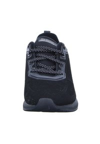Scarpa sportiva nera con tomaia in tessuto texturizzato, design con lacci e colletto imbottito. Dettagli notevoli includono una punta perforata e suola in gomma.
