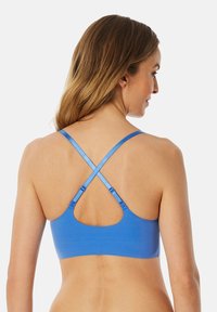 Blauer Sport-BH mit Racerback-Design, weichem Stoff, verstellbaren Trägern und abgerundetem Schnitt auf der Rückseite für Komfort und Unterstützung.