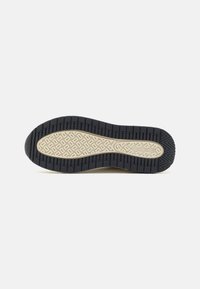 Rubber shoe sole with a textured black exterior and a beige patterned center. Features a thick grip for traction and durability.