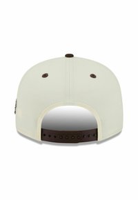 Casquette snapback beige clair avec une sangle ajustable marron et des œillets de ventilation, vue de l'arrière.