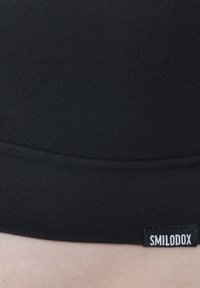 Vita elastica nera senza cuciture con una texture liscia e un'etichetta del marchio "SMILODOX" in bianco. Il materiale appare morbido e aderente.