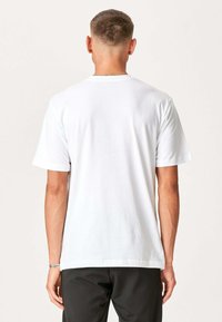 Hvid bomulds t-shirt med korte ærmer, rund hals og lige snit. Ingen synlige logoer eller mønstre, glat tekstur.