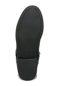 Suola in gomma nera di una scarpa con superficie testurizzata e una leggera curvatura. Nome del marchio "VIONIC" impresso vicino al tallone.