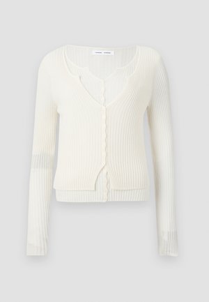 Ribiga, pika varrukaga kardigan heledas valges, sügava V-kujuga kaelusega, nööbiga kinnituse ja narmastega äärtega nööpide ja serva juures.