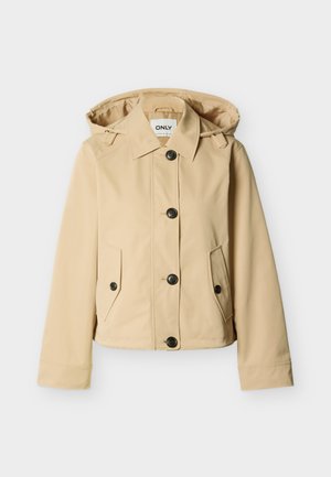 Bēšs kapucis ar gariem piedurknēm, pogātas priekšējas daļas un divas pogām aiztaisāmas kabatas ar aizsargplāksnēm uz vienkrāsaina fona.