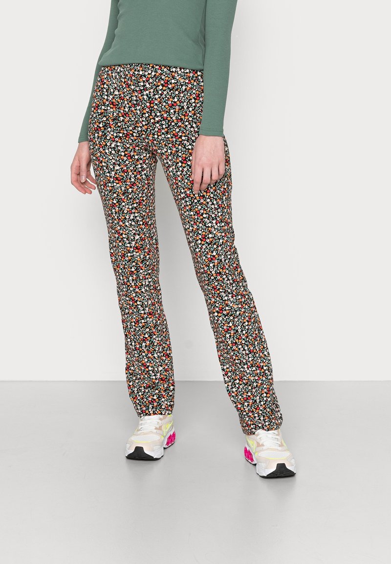 Bloemenpatroon broek heeft een zwarte achtergrond met kleine rode, witte en gele bloemen. Het materiaal lijkt lichtgewicht met een slim fit.