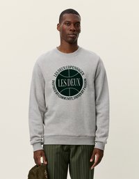 Γκρι φούτερ με στρογγυλό πράσινο λογότυπο που περιέχει το κείμενο "LES DEUX COPENHAGEN". Ριμπ μανσέτες και στρίφωμα, μαλακό υλικό, άνετη εφαρμογή.