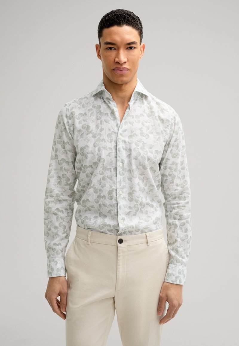 Hellgrünes, gemustertes Hemd mit Kragen, langen Ärmeln und weißem Hintergrund; kombiniert mit cremefarbenen Hosen.