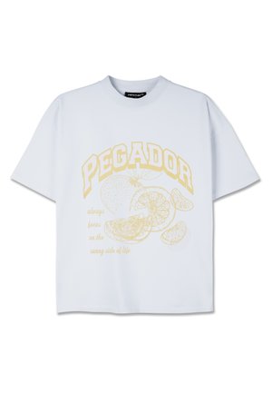 White short-sleeve t-shirt featuring a yellow graphic design with the word "PEGADOR" and citrus fruit illustrations along with text below.