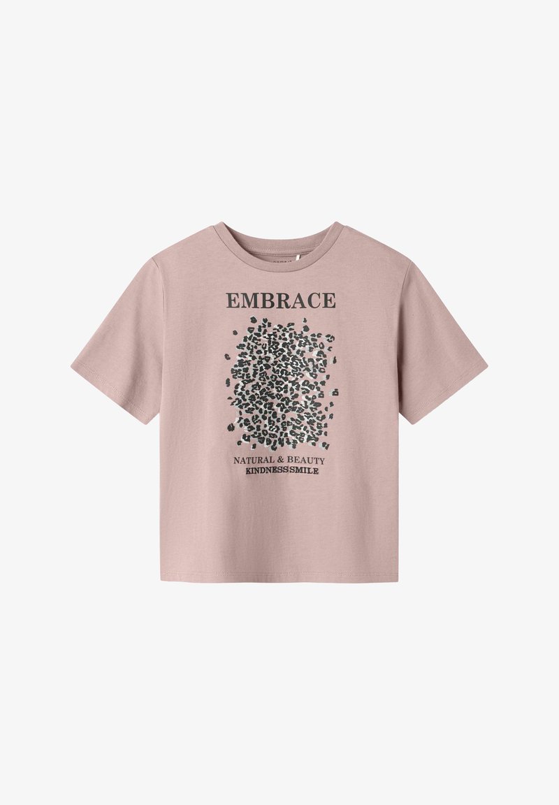 T-shirt en coton rose clair à manches courtes, avec un texte graphique noir et des motifs en points au centre. Coupe décontractée.