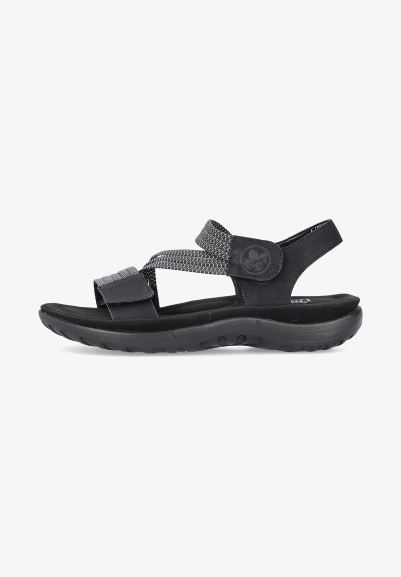 Sandalias negras con correas ajustables que presentan una tela texturizada y cuero suave. La suela es de goma con un dibujo en el relieve para mayor agarre.