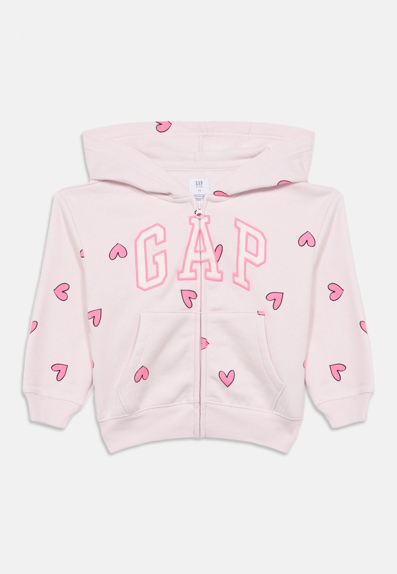 Felpa con cappuccio rosa chiaro con zip frontale, caratterizzata da un grande logo "GAP" e piccoli cuori rosa come motivo ripetuto. Tessuto morbido al tatto.