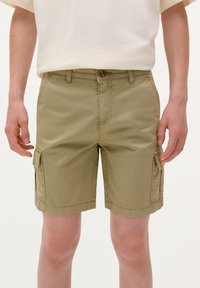 Khaki szorty cargo o prostym kroju, z dwoma bocznymi kieszeniami i zapięciem na guzik. Wykonane z lekkiego materiału z widocznymi detalami szwów.