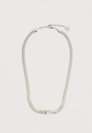 Srebrny naszyjnik na łańcuszku z płaskim, zygzakowatym wzorem. Wyposażony w centralny zamek i regulowaną długość z małą metką. Gładka metaliczna tekstura.