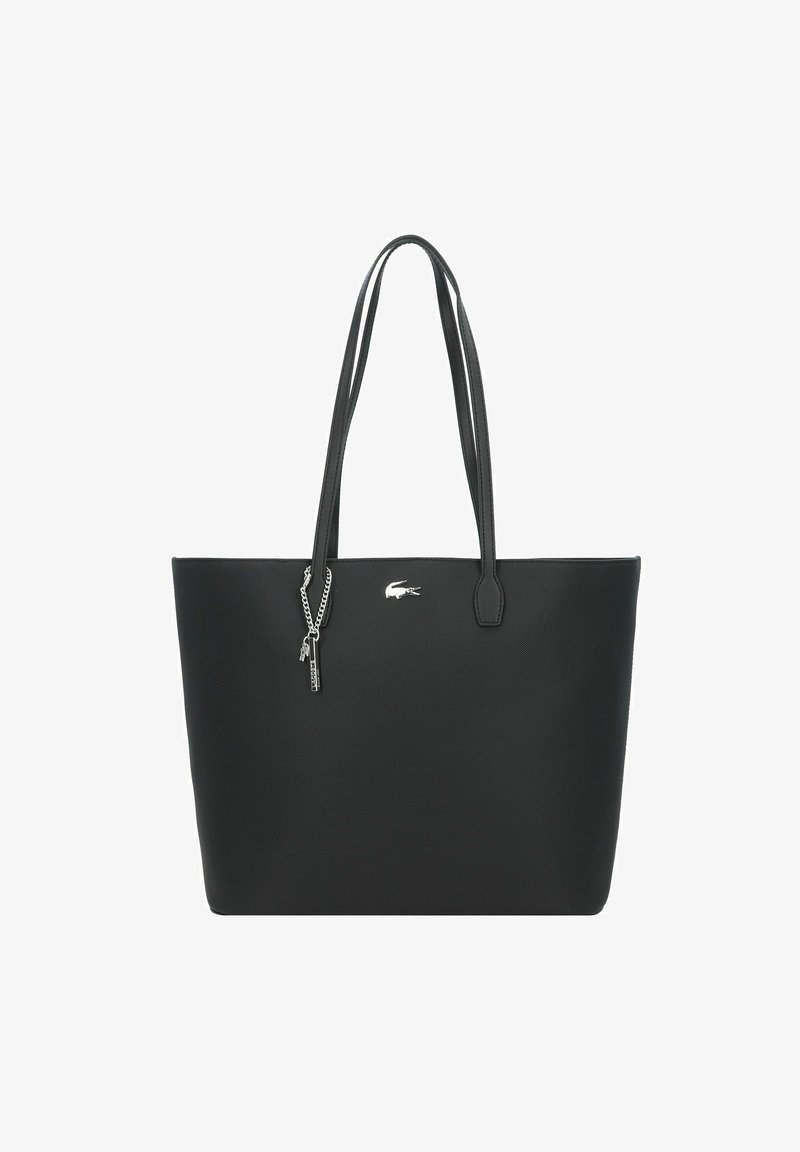 Black synthetic tote bag with dual handles, smooth texture, and a small silver Lacoste logo. Features an attached silver chain detail.