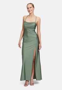 Langes grünes Kleid mit taillierter Oberseite, Drapierung und einem Oberschenkel hohen Schlitz. Hergestellt aus glattem Stoff mit dezenten schimmernden Akzenten.