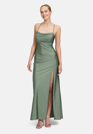 Langes grünes Kleid mit taillierter Oberseite, Drapierung und einem Oberschenkel hohen Schlitz. Hergestellt aus glattem Stoff mit dezenten schimmernden Akzenten.