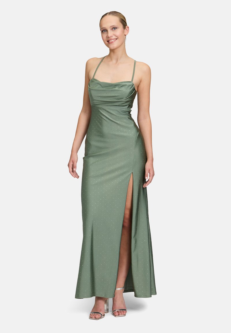Langes grünes Kleid mit taillierter Oberseite, Drapierung und einem Oberschenkel hohen Schlitz. Hergestellt aus glattem Stoff mit dezenten schimmernden Akzenten.