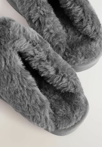 Gray furry slippers with a soft, plush texture, open-toe design, and durable rubber sole. The interior features thick, fluffy lining.