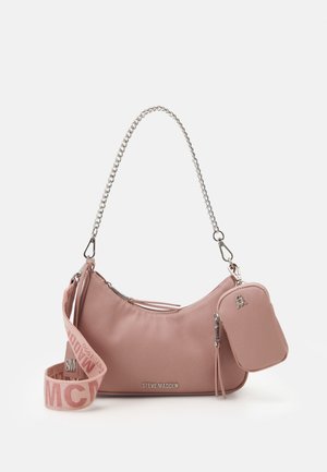 Różowa torebka Steve Madden w odcieniu brzoskwiniowym z srebrnym łańcuszkiem, odpinanym materiałowym paskiem z logo oraz małą zamykaną na suwak kieszonką przymocowaną z boku.