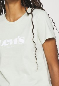 T-shirt in cotone verde menta con il logo bianco di Levi's centrato sul petto, maniche corte e vestibilità rilassata.