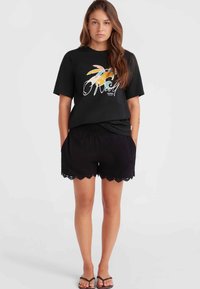 Sort t-shirt med en flerfarvet palme grafik, parret med sorte shorts med bølget pynt og elastisk talje.