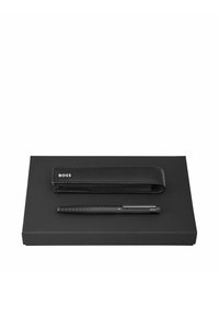 Stylo noir avec une prise en main texturée et une housse en cuir noir assortie gravée "BOSS" sur une boîte rectangulaire noire.