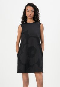 Black sleeveless dress with large floral pattern, straight cut, and soft texture. Features a round neckline and side pockets.