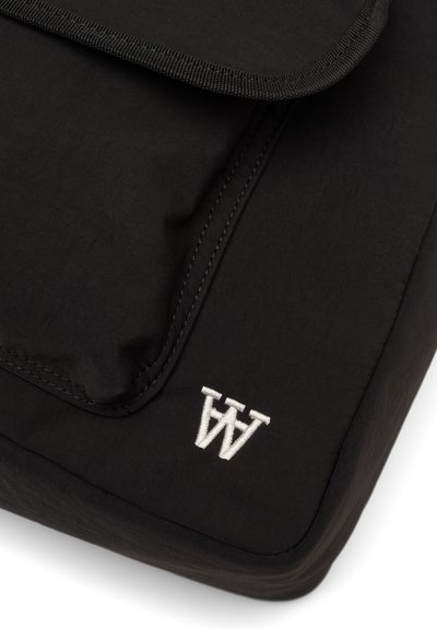 Housse pour ordinateur portable en tissu noir à texture lisse, avec un logo brodé en blanc et une fermeture à rabat avec bords renforcés.