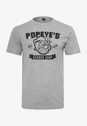 Camiseta gris con gráfico negro de la cara de Popeye fumando una pipa, texto "POPEYE'S Est. 1929" encima y "BARBER SHOP" debajo.