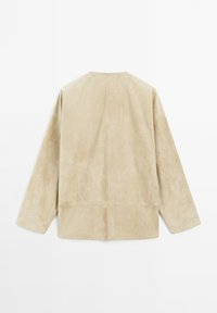 Beige Wildlederkleidung mit lockerer Passform, langen Ärmeln und geradem Saum. Nahtdetails sind an der Rückseite und an den Seiten sichtbar.