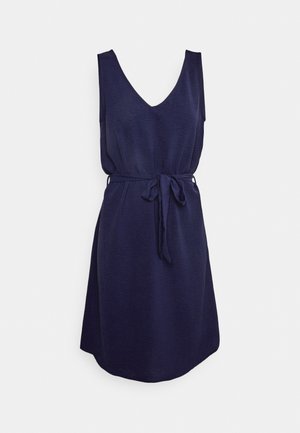 Ærmeløs marineblå kjole med V-halsudskæring, rynket talje og bælte i samme stof, vist på en hvid baggrund.