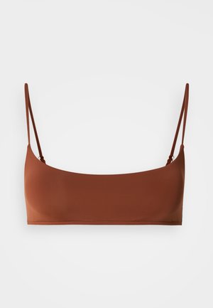 Barna, rövid fazonú bikini felső vékony, állítható vállpántokkal, egyszerű fehér háttéren.