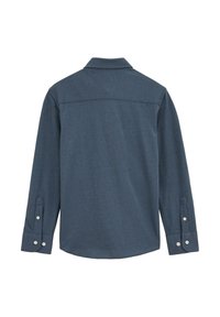 Tumši zila auduma krekls ar garām piedurknēm, apkakli, pogām pie piedurknēm un taisnu aizmugures apakšmalu. Tam ir vienkārša tekstūra bez rakstiem.