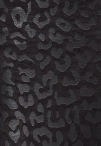 Czarna tkanina z wypukłym, błyszczącym wzorem w panterę. Teksturowany wygląd kontrastuje z matowym tłem, które ma różnorodne, organiczne kształty.