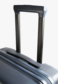 Maleta rígida con una superficie texturizada de color azul oscuro, que cuenta con un mango negro retráctil y un mango superior liso.