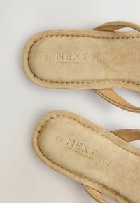 Sandales en daim beige avec des sangles larges, bords cousus, taille 6½/40, marquées "NEXT Forever Comfort" sur des semelles rembourrées.