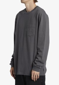 Långärmad grå T-shirt i mjukt material med rund halsringning, med en bröstficka och präglad "D94" design. Rakt snitt.