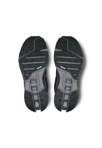Black rubber outsole with textured grip patterns and grooves for traction. Grey accents on a solid base enhance stability and durability.